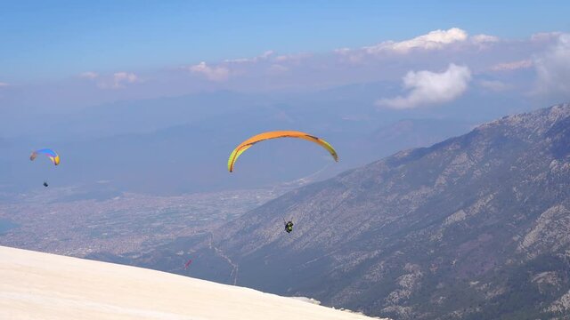 Paraglider soaring on paragliding in the sky in mountain. Extreme sport in mountains