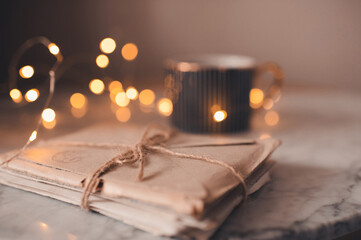 Laced old romantic handwritten paper letters with cup of coffee and glow lights at background close up. Love concept. Pleasant memories. Cozy atmosphere.