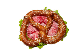 Pretzel with salami and lettuce isolated on a white background.