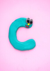letter c from plasticine on a pink background