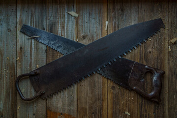 Vintage one-handed saw and handsaw on wooden crafting table of workshop