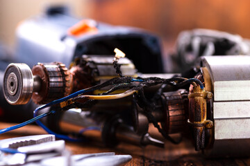 Power tool repair. Details of electrical appliance and repair tools on a wooden table in a repair shop