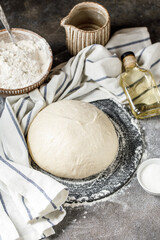 Pizza dough on rustic background. Cooking time. Ingredients for making dough. 