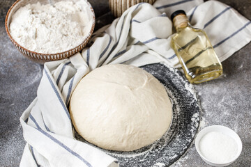 Pizza dough on rustic background. Cooking time. Ingredients for making dough. 