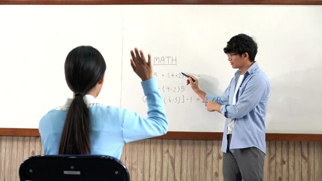 Educational concept a young smart male teacher explaining decision of hard math in a classroom