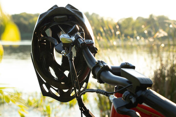 bicycle helmet on the handlebars of an e-bike at sunset in nature, cycling helmet
