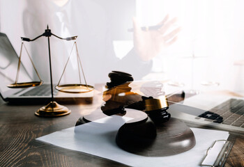 Justice and law concept.Male judge in a courtroom with the gavel, working with, computer and docking keyboard, eyeglasses, on table in morning light