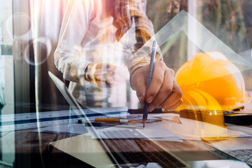 Construction engineer working at blueprint to build large commercial buildings in office....