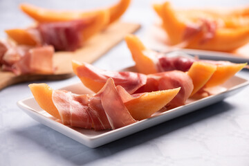 Fototapeta na wymiar Fresh melon and parma ham on white plate
