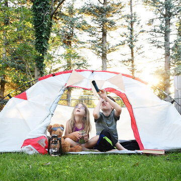 Kids Sitting Outside in Yard inside Tent