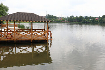 Wooden gazebo on shore of pond