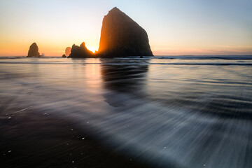 haystack rock at sunset with receding tide