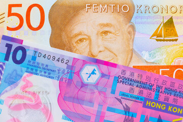 A macro image of a gray and orange fifty kronor note from Sweden paired up with a pink and purple, plastic ten dollar bill from Hong Kong.  Shot close up in macro.