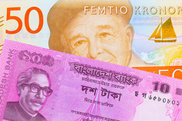 A macro image of a gray and orange fifty kronor note from Sweden paired up with a pink ten taka bank note from Bangladesh.  Shot close up in macro.
