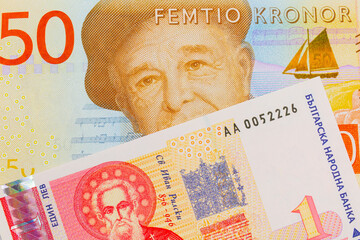 A macro image of a gray and orange fifty kronor note from Sweden paired up with a red and white one lev bank note from Bulgaria.  Shot close up in macro.