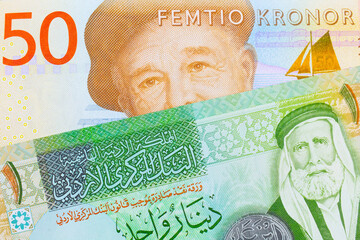 A macro image of a gray and orange fifty kronor note from Sweden paired up with a green and yellow one dinar note from Jordan.  Shot close up in macro.