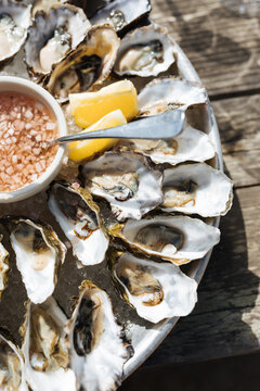 Fresh oysters on the half shell with sauce and lemons