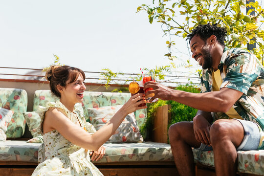 Happy diverse friends proposing toast on terrace
