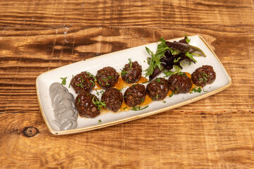 Beef meatballs with gray cream sauce of radishes, parsley and lettuce shoots.