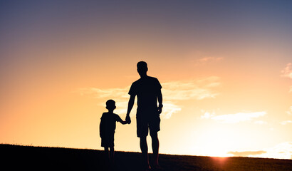 father and son holding hands walking 