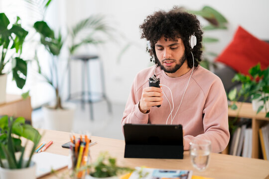 Arab man using audio recorder in studio