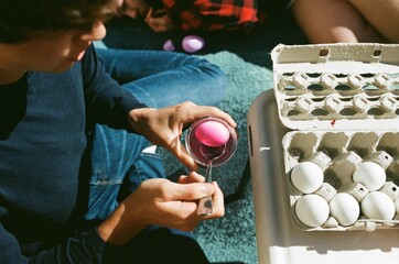 Teen boy coloring eggs