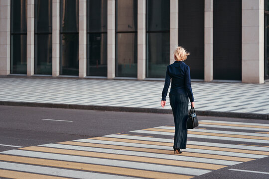A woman walks along a pedestrian crossing.