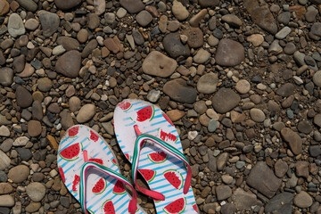 slippers flip flops on a stone beach