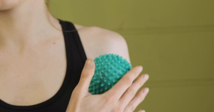 Self-massage of the shoulder ball for the massage. Girl makes a myofascial release of the shoulder joint. Relaxing muscles