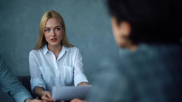 Close-up portrait of young skilled female hr manager leader holding job interview with vacancy candidate at meeting in corporate office. Caucasian headhunters having job interview with young man