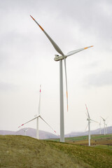 Fototapeta premium Electricity Wind turbine landscape. Wind farm energy eco friendly in mountains. Renewable clean energy production. Vertical photo