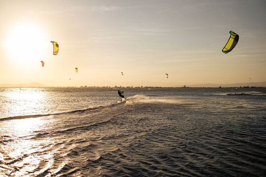 Anonymous kitesurfers during sunset on the sea