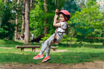 Fragile, beautiful child on a rope flew to the ground. A fearless child actively spends time