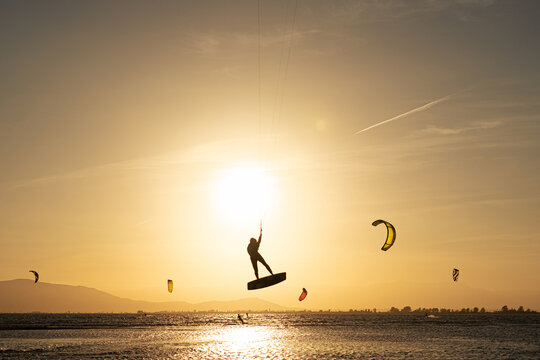 Anonymous man kitesurfing during sunset on the sea