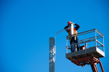 Worker in lift bucket repair light pole