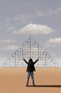 A man with raised arms stands in front of a giant protractor