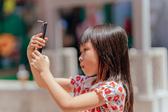 little girl taking pictures with mobile phone