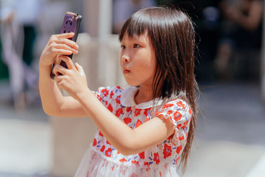 little girl taking pictures with mobile phone