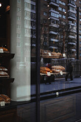 Showcase of a small bakery on a Moscow street. Reflection in the window
