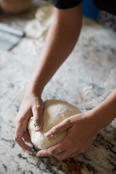 Anonymous baker shaping bread from dough