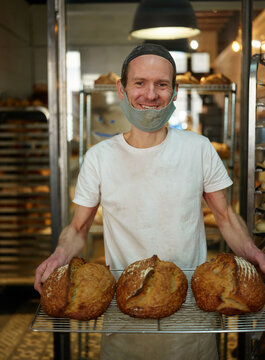 Portrait of a baker holding bread loafs