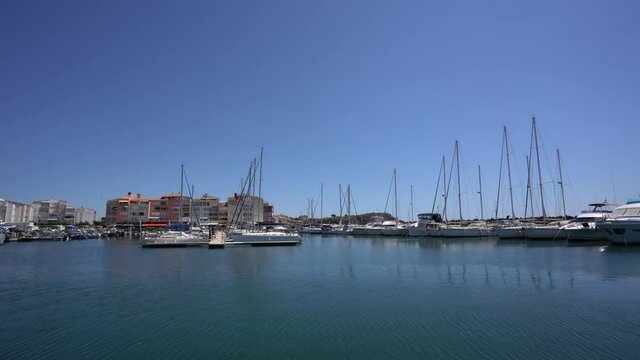 Port du Cap a small fishing port with yachts and floating vessels in Agde France, Pan Right Reveal Shot