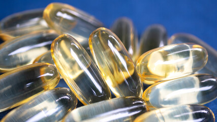 Astonishing closeup of Omega 3 capsules (pills), stacked together in a pile. Medical journals and...