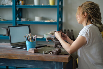 artisan pottery tutor in art studio. woman ceramist teaches an online lesson or leads a video master class on creating ceramic products