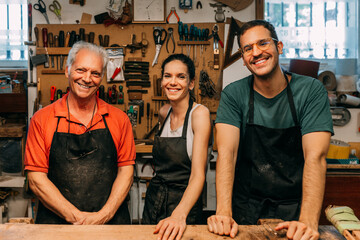 Happy family posing in their traditional guitar making workshop