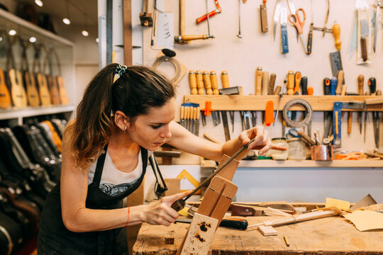 Young Woman working in handcrafted Spanish guitar