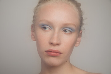 Young freckled model with blue eyeshadows