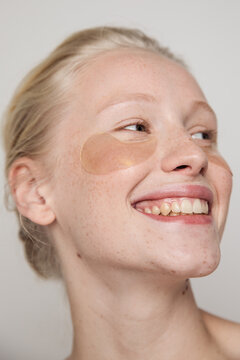 Young happy freckled model with golden under-eye patches