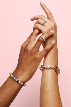 Two female hands with jewelry on holding each other