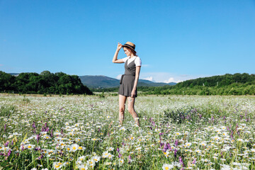 woman traveling on the field of daisies in the spring